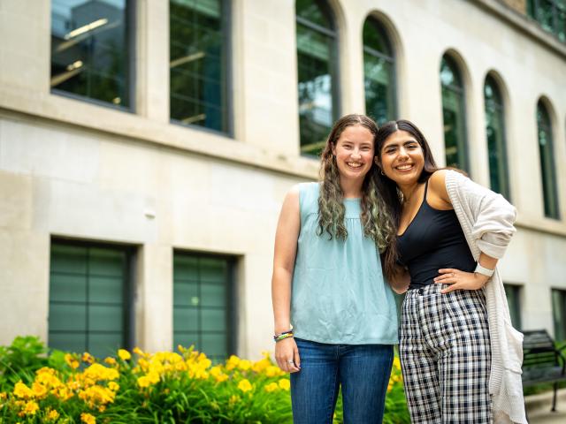 Two students hugging and smiling outside RJF Hall
