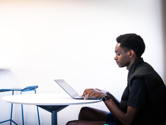 A person sits a laptop.